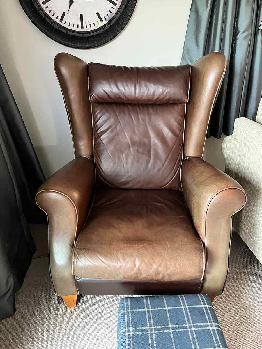 faded leather wing-back chair