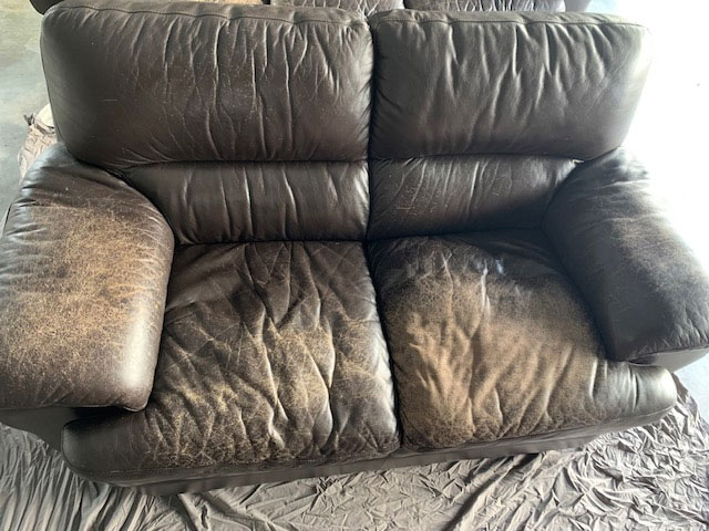2 seater couch with worn out leather