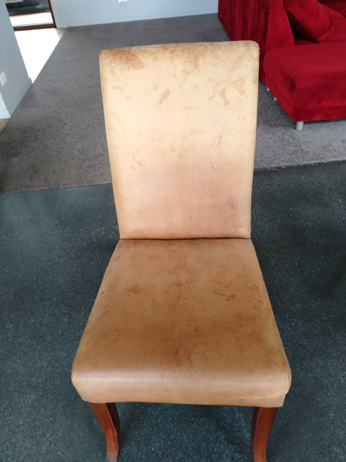 Faded stained leather chair