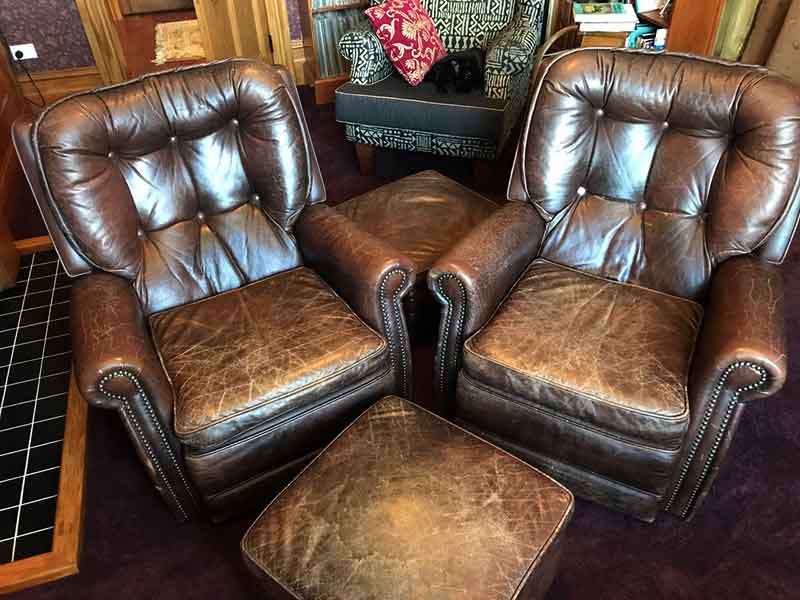 Cracked and faded leather chairs and footstool