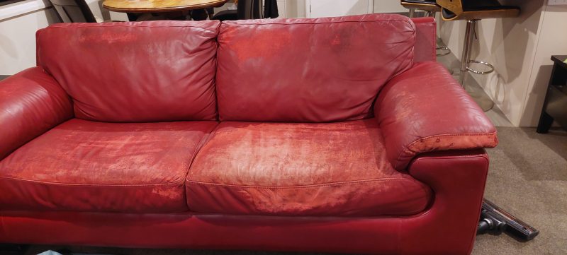 Worn red leather settee